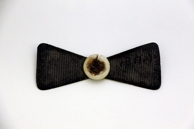 A plastic bow tie with a plastic button in the center.
