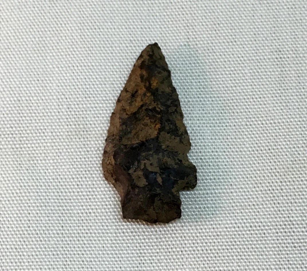 A chipped piece of stone with jagged angles and a sharp point.