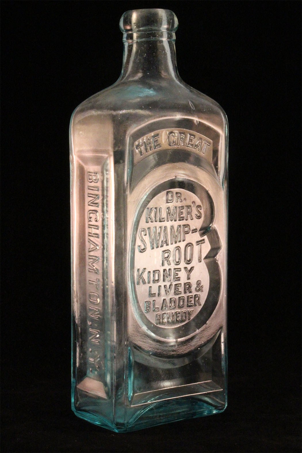 A medicine bottle with embossed letters on all sides.