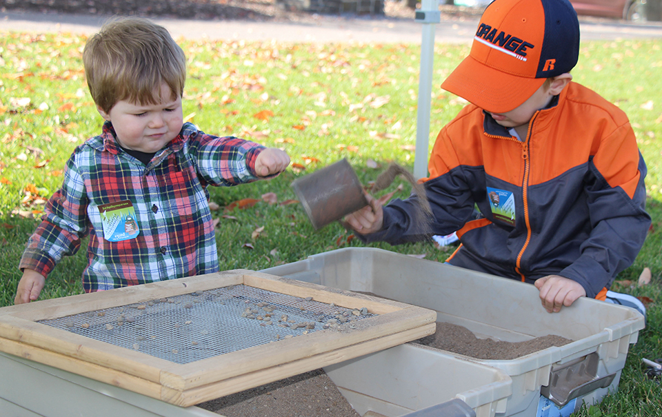 A young child digs in a box.