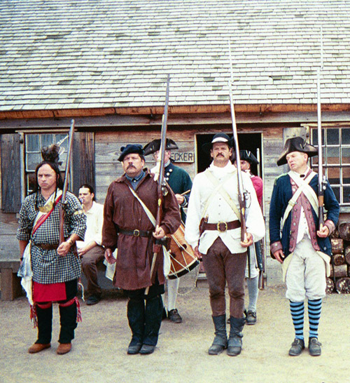 continental militia men stand in a line, they wear different textured coats and clothing.