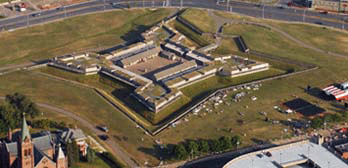 a bird's eye view of the park: star-shaped large wooden building on a green patch of earth