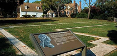 stones remains arranged in square box on ground, green grass surrounds