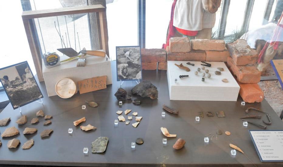 Dozens of fragmented artifacts in various colors sit inside a glass box. Dozens of fragmented artifacts in various colors sit inside a glass box.