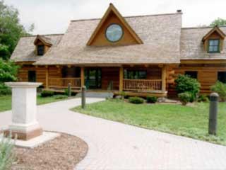 a log cabin in a green field