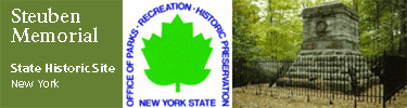 green maple leaf, symbol of NYS parks assoc, grey brick monument with rod iron fence, Steuben Memorial NYSHS