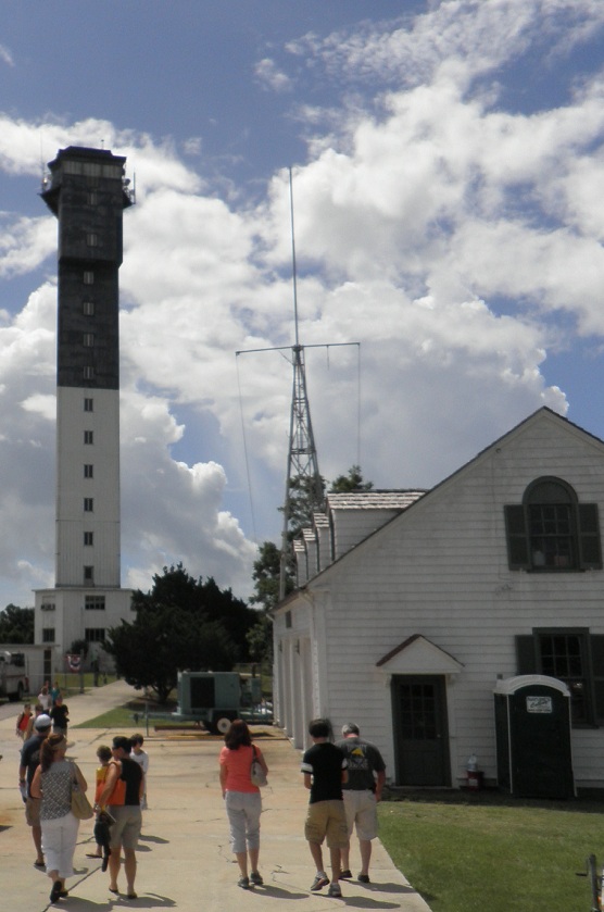 Sullivan's Island Lighthouse and historic garage with visitors in the foreground