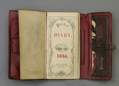 Booth trifold leather datebook and diary opened to the title page with "Pocket Diary, 1864"