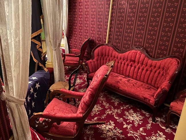 Plush red carpeted interior of the state box, with luxurious red furniture