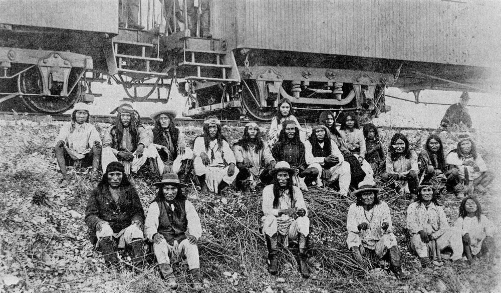 Apaches sitting outside train cars
