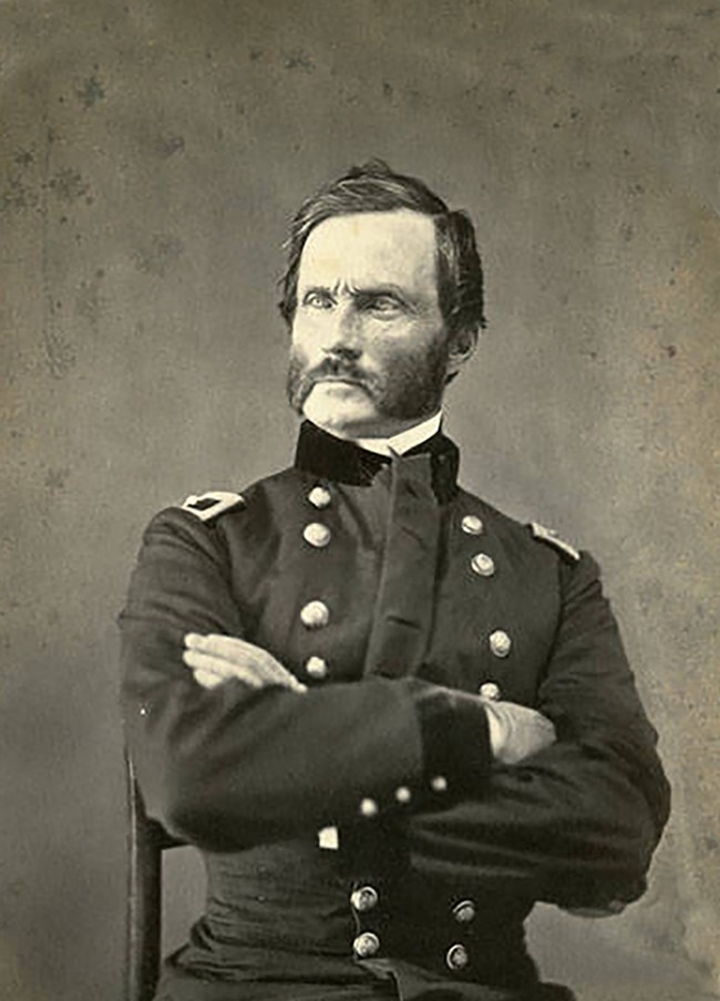 General James Carleton, seated, with arms crossed