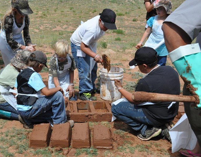 Junior Ranger making adobe bricks