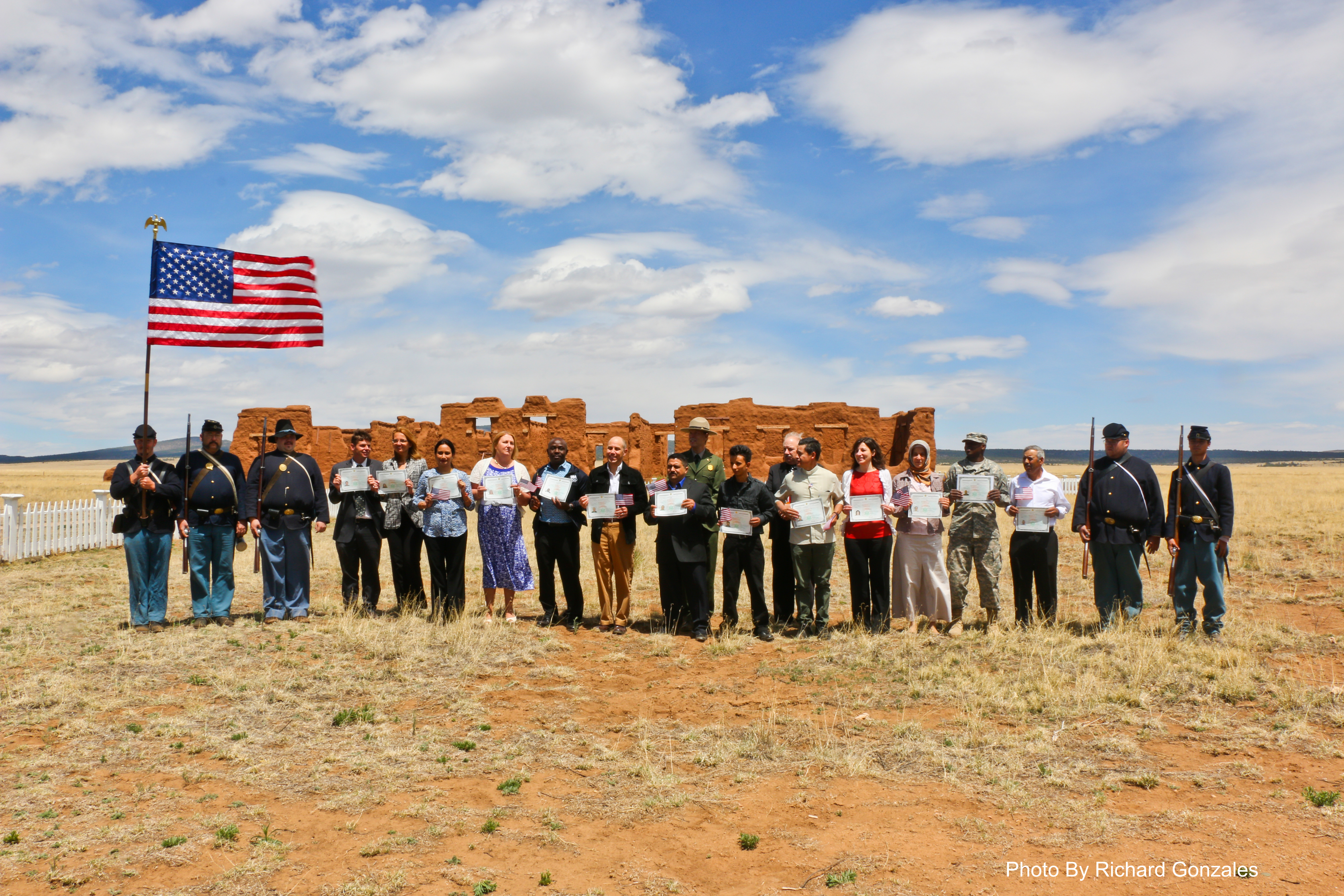 Newly naturalized citizens stand in front of Fort Union hospital