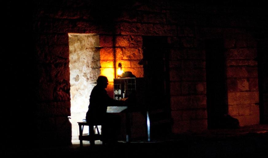 Officer sitting next to writing desk. 2013 Candlelight Tours.