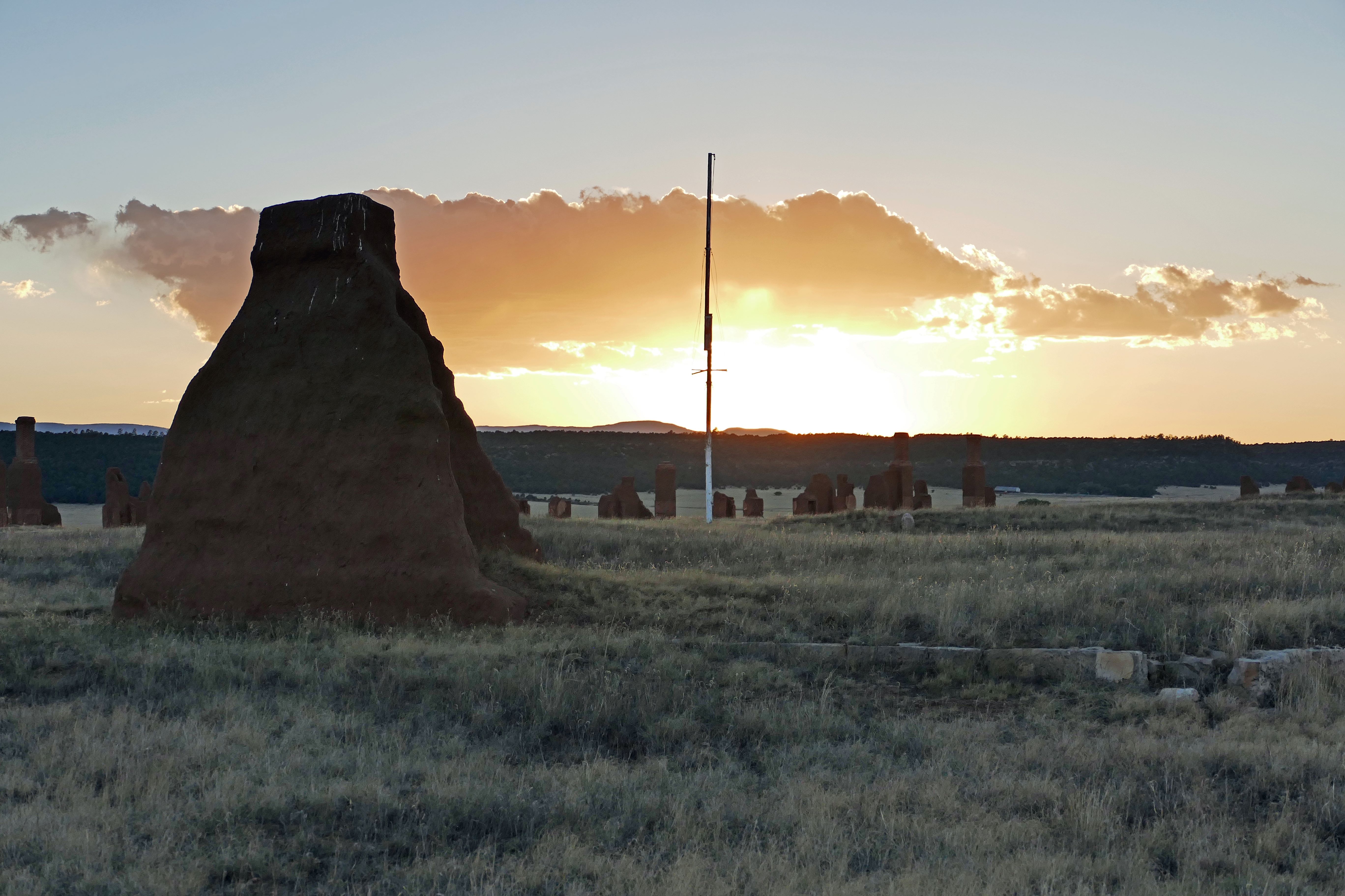 The sun sets behind the adobe walls and stone foundations of historic Fort Union.