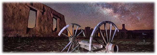 nighttime starry sky over adobe walls and old wagons