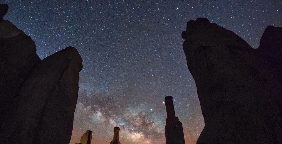The milky way and a sky full of stars visible above adobe ruins