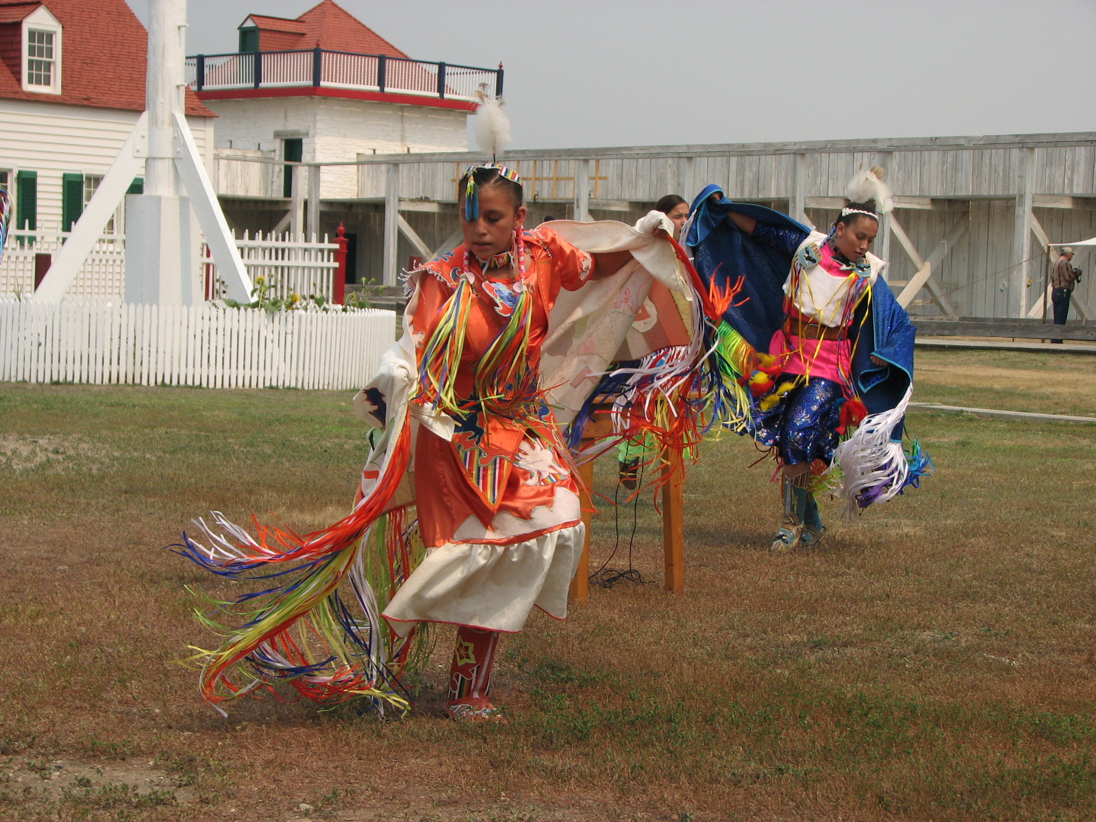 Fancy Shawl Dancing during Indian Arts Festival. Woman in bright colored dance outfit dances in the courtyard.