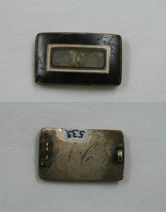 Mourning brooch showing black enamel front and initialed back