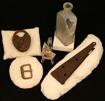 Assorted artifacts arrayed on pillows over a black background.