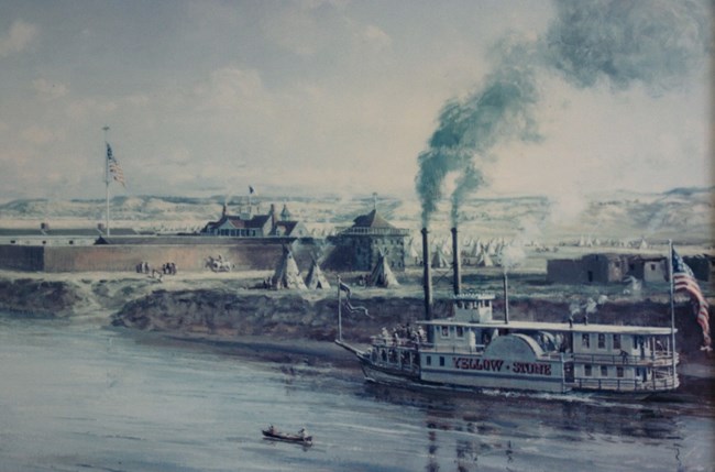 A white steamboat on a river with a walled structure surrounded by tipis up the bank.
