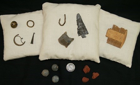 Assorted trade goods arrayed on pillows and a black background.