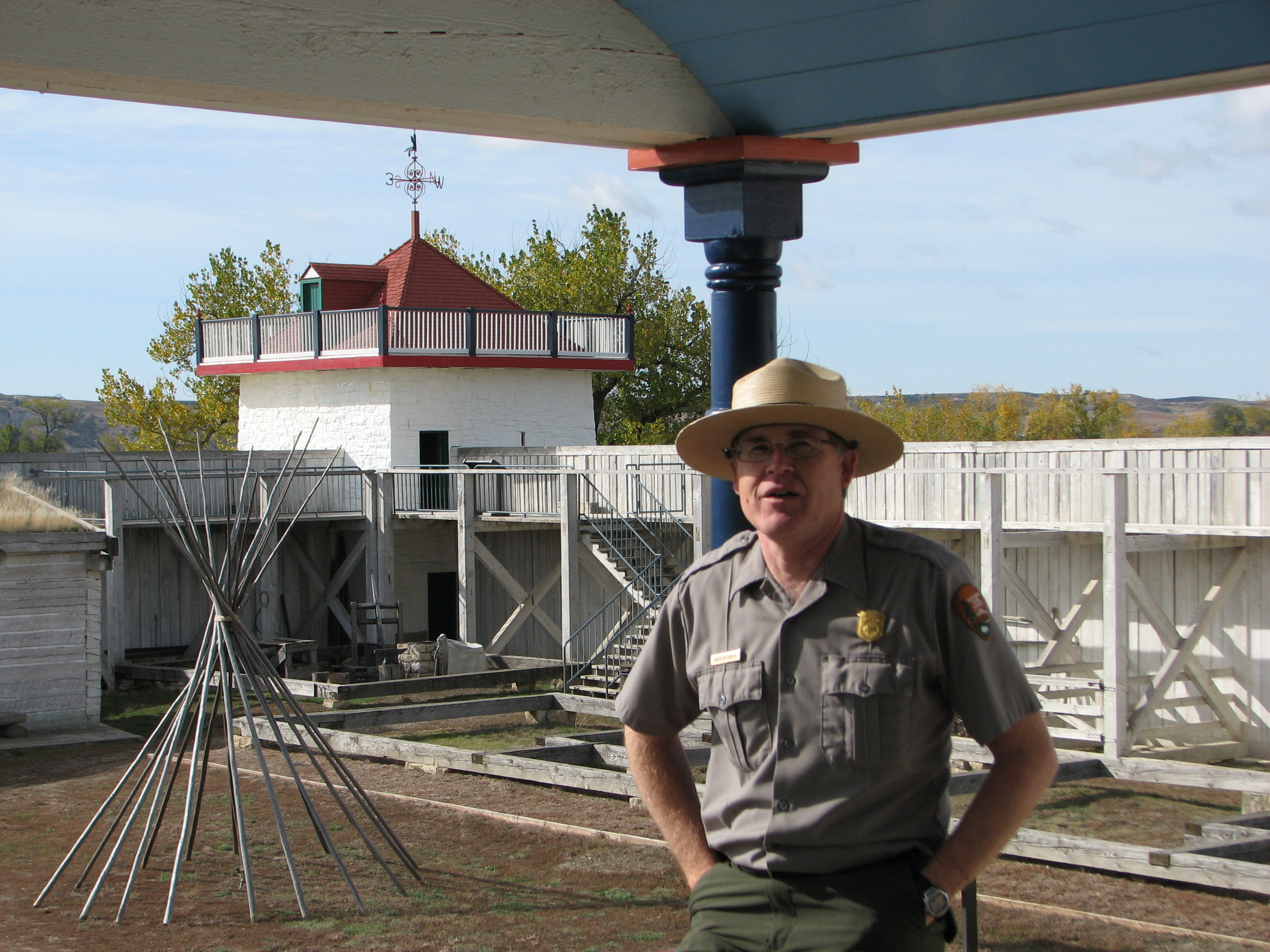 Andy Banta, Park Superintendent Man in Park Ranger Uniform sitting on railing with historic fort in background