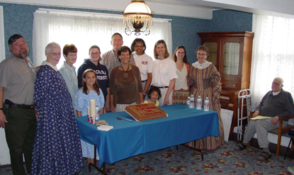 Image of staff and volunteers standing around a cake commemorating the McLoughlin House Site's third anniversary Image of staff and volunteers standing around a cake commemorating the McLoughlin House Site's third anniversary
