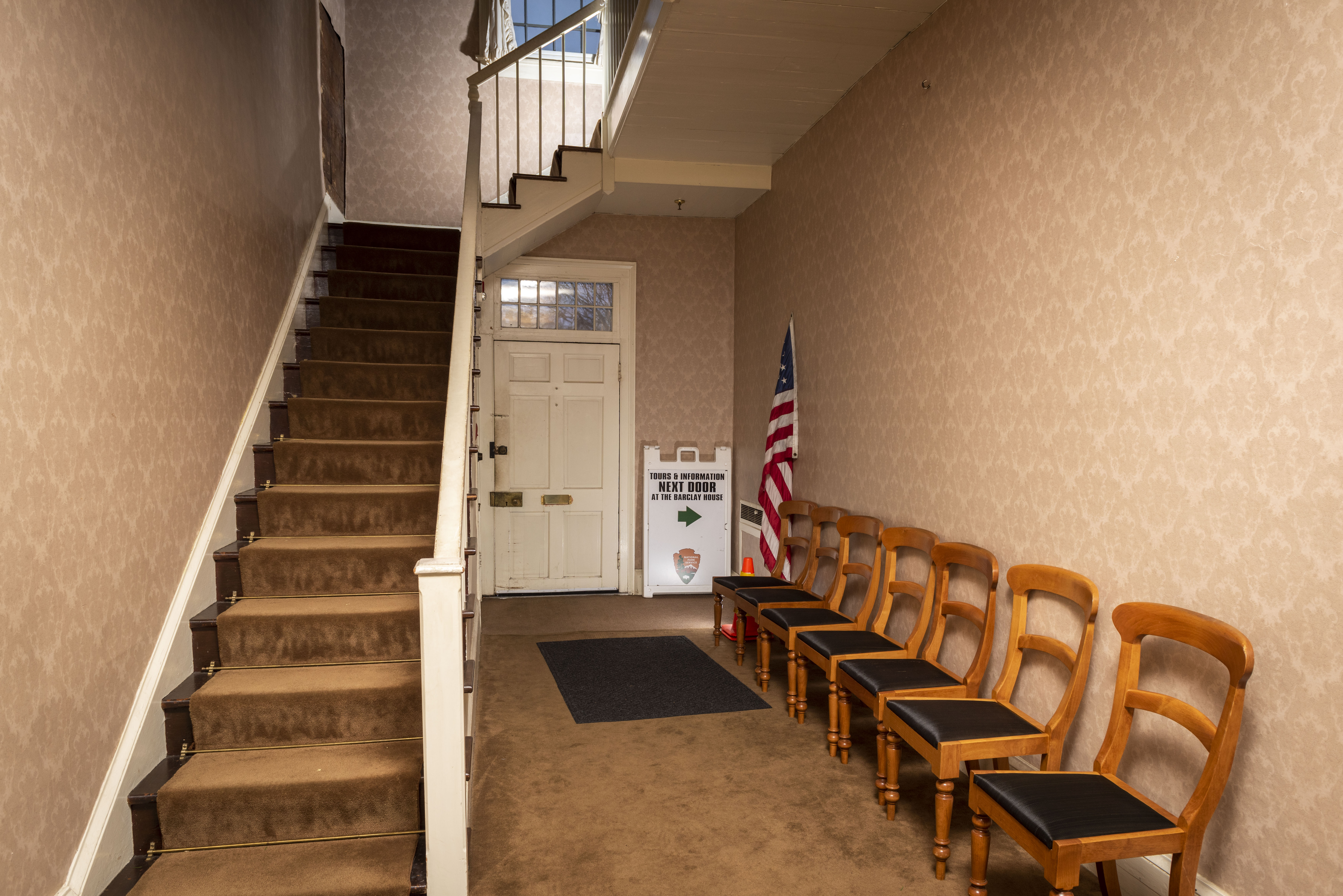 The interior of the McLoughlin House entry hall, facing the stairway to the second floor and the former back door.