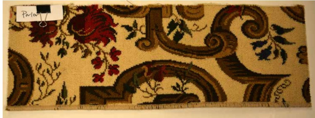 A sample of carpet with an ornate floral design on a cream-colored background.