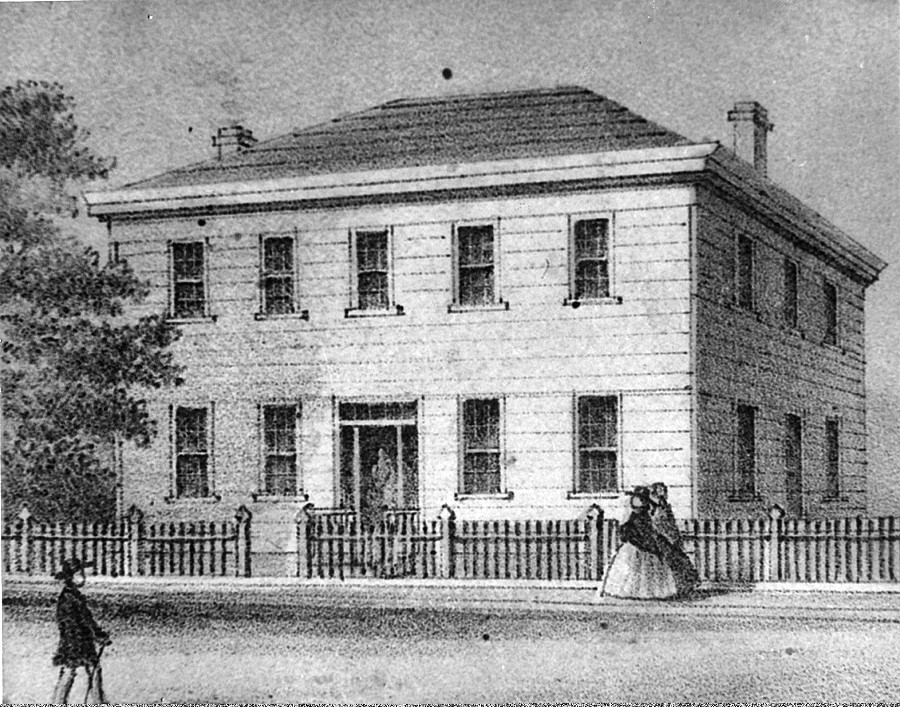 A black and white lithograph image of a square white house on a street.