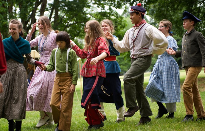 Photo of Living History School participants dancing for the public at a park special event.