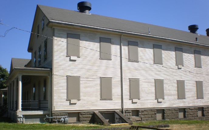 View of the west side of one of the large barracks buildings that frames the south side of the historic Parade Ground at Fort Vancouver NHS