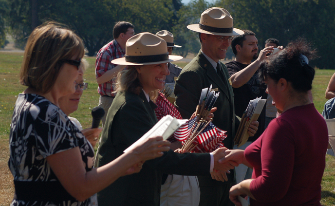 Image of dignitaries welcoming new U.S. citizens as part of the annual Citizenship Ceremony at the bandstand at Fort Vancouver NHS.