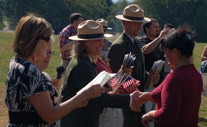 Image of dignitaries welcoming new U.S. citizens as part of the annual Citizenship Ceremony at the bandstand at Fort Vancouver NHS.