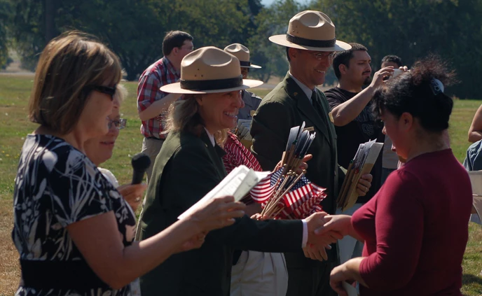 Image of dignitaries welcoming new U.S. citizens as part of the annual Citizenship Ceremony at the bandstand at Fort Vancouver NHS.