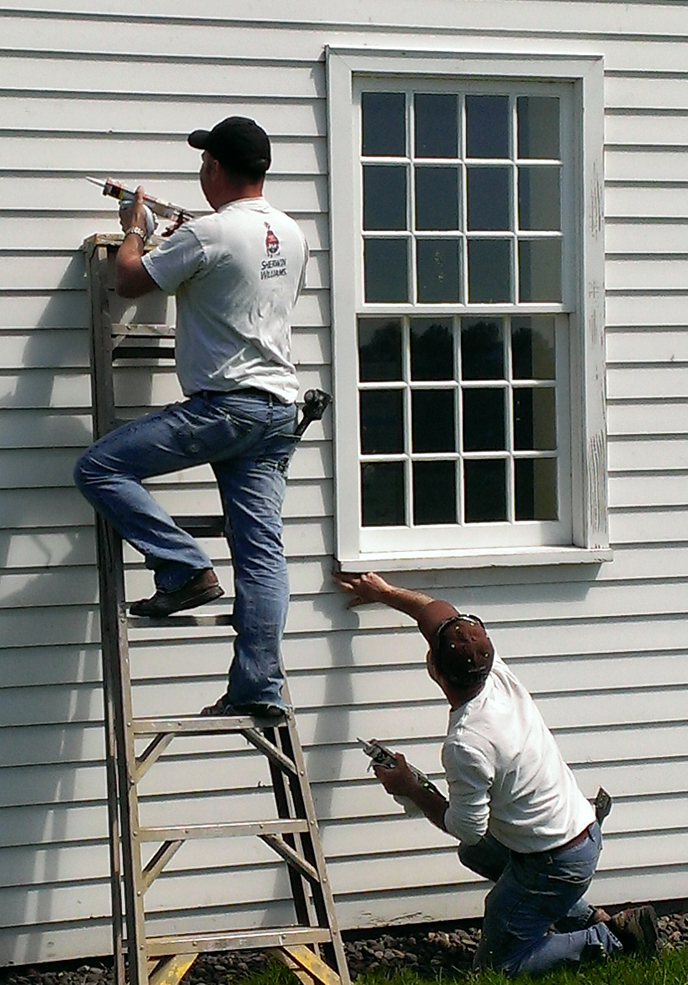 Two contractors at work prepping the Counting House for repainting.