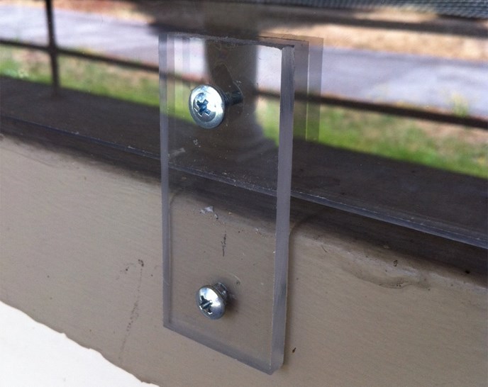 Detailed photo of plexiglass window covering and screw used to preserve a historic window at East Vancouver Barracks