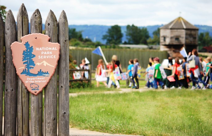 Photo of students walking behind the park sign