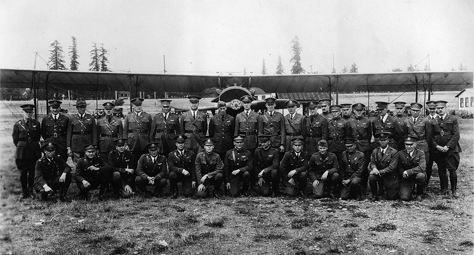 JN-4 at Pearson Field Black and white photograph of men in military uniforms standing in front of a JN-4 Jenny aircraft.