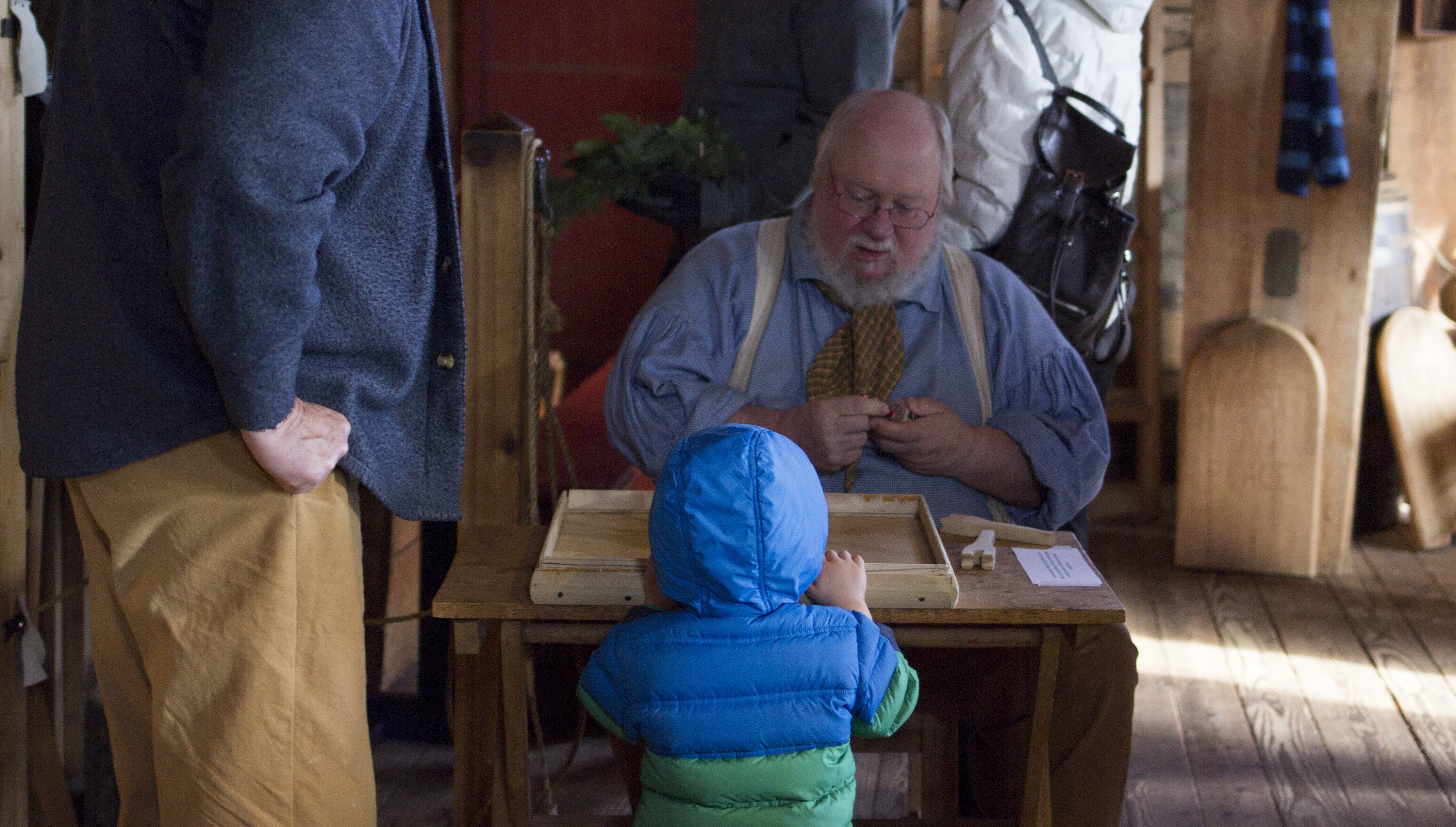 Heritage Holiday photo Park volunteer demonstrating to a visitor the use of a toy top.