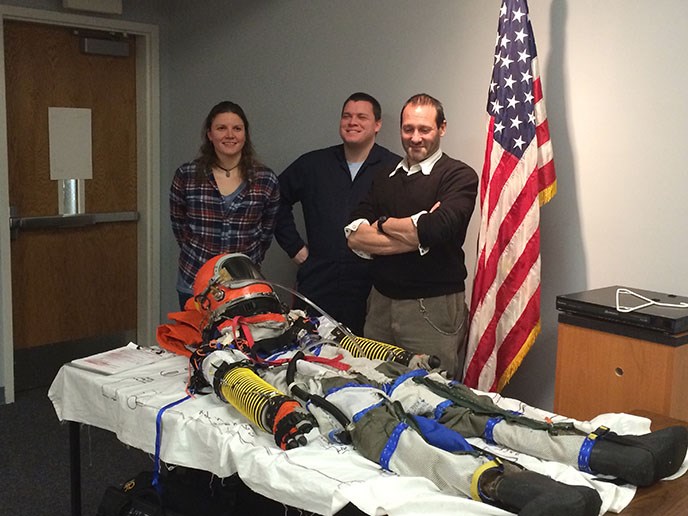 Photo of PSU Anthropology Professor Dr. Cameron Smith poses with his build team and his home built pressure flight suit he intends to conduct high altitude tests with this year.