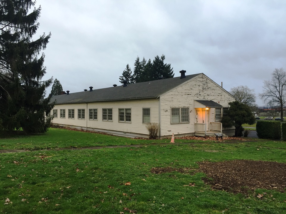 Photo of long rectangular building with yellow paint.