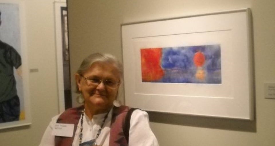 Artist Lois Thadei poses with painting