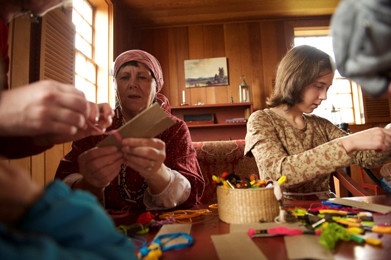 Volunteers leading a tassel making demonstration