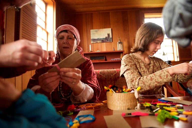 Volunteers leading a tassel making demonstration