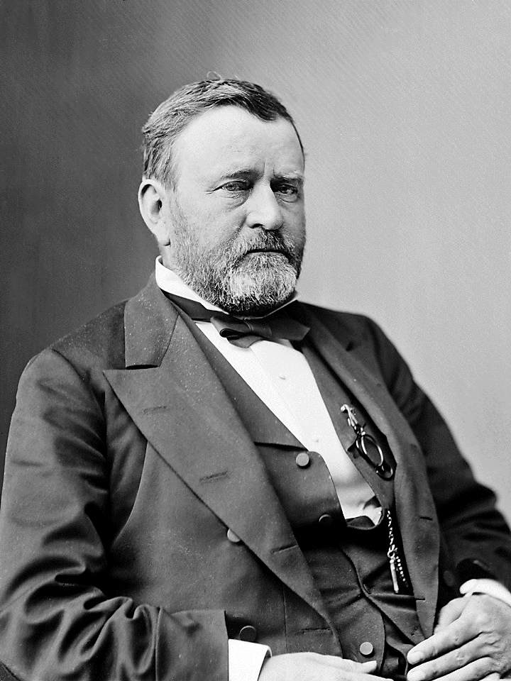 Three-quarters length photograph of seated man.