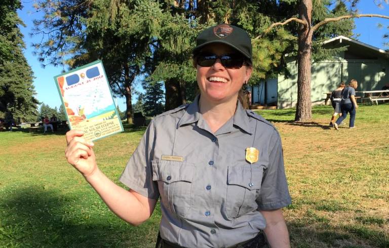 Park ranger holding eclipse glasses at Fort Vancouver National Historic Site