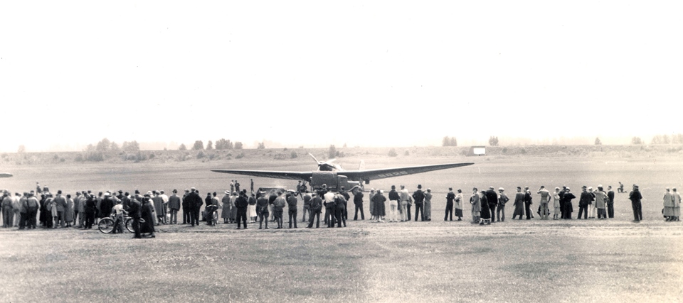 ANT-25 aircraft sits in field surrounded by onlookers