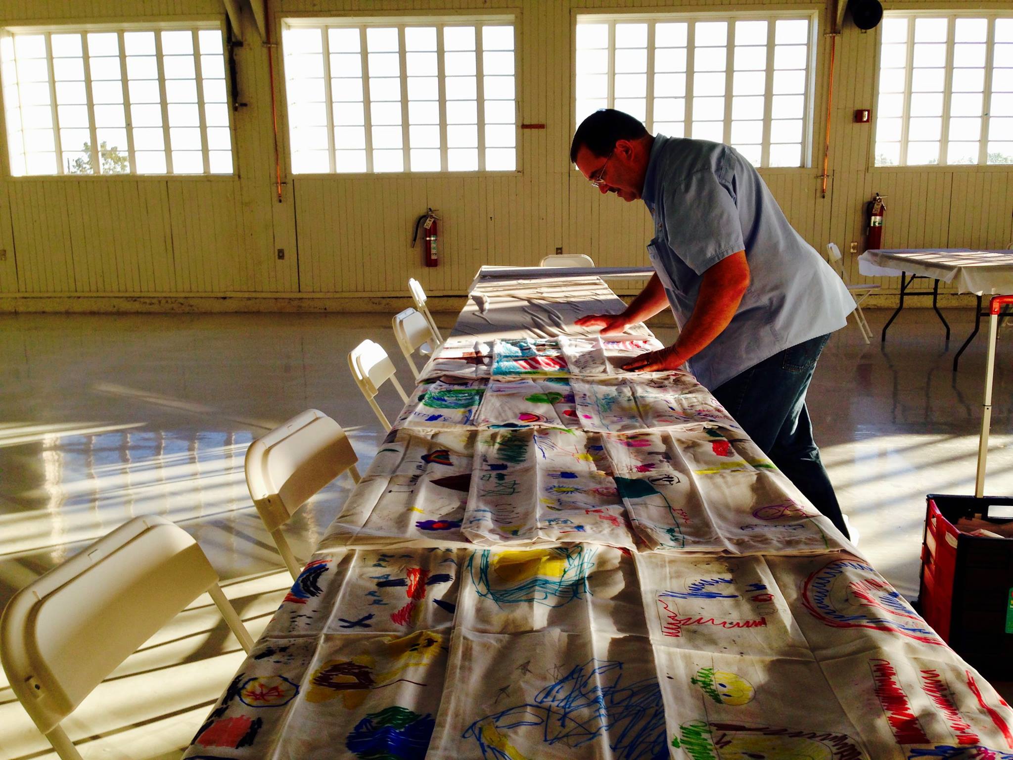 Operation Pillow Talk staff lay out pillowcases decorated by local schoolchildren